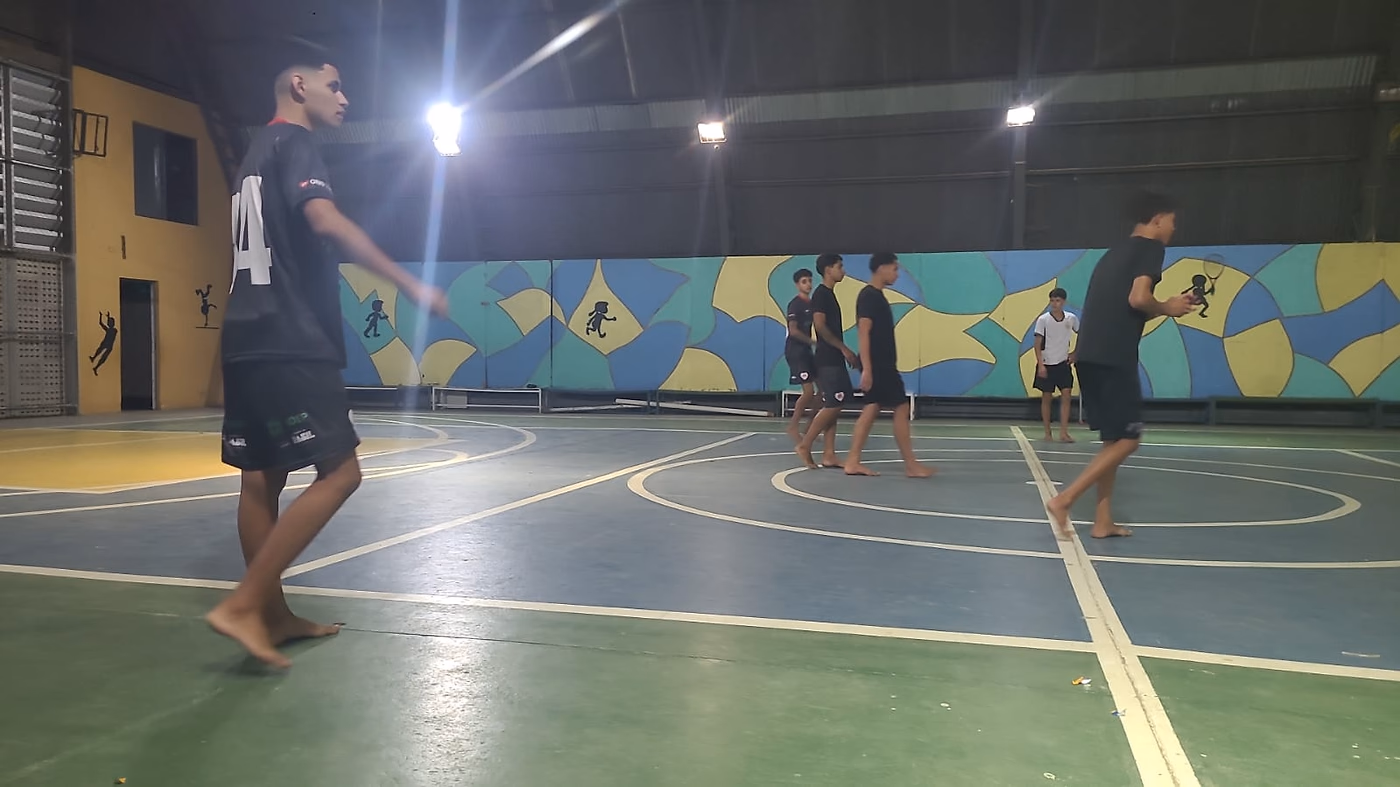 Partida em andamento na quadra coberta, durante a aula do projeto.