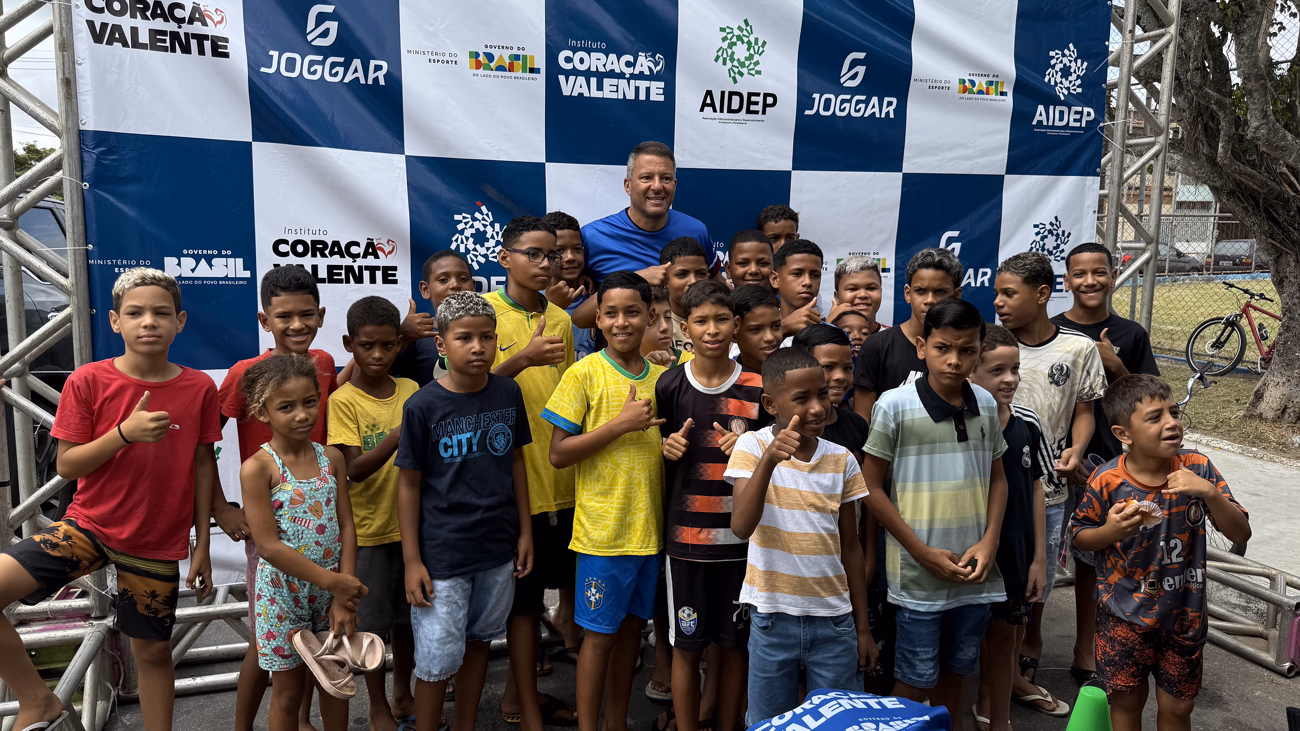 Crianças e adolescentes do Bugio reunidos diante do painel do projeto, no dia da inauguração do polo.
